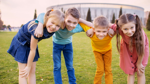 Happy children play and relax in the summer park.