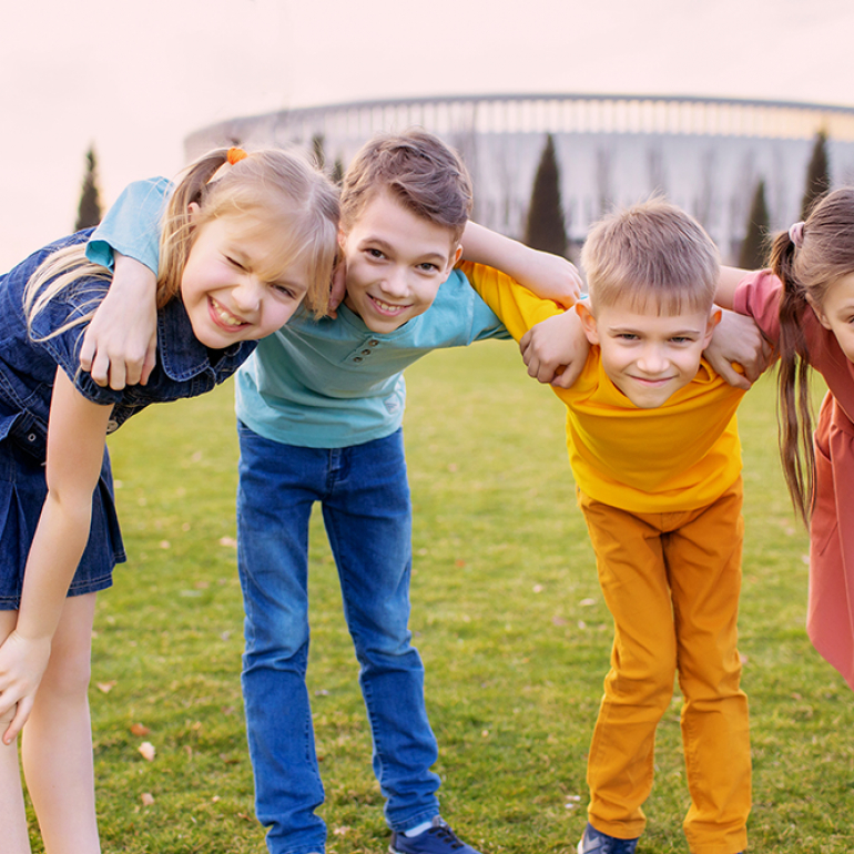 Happy children play and relax in the summer park.